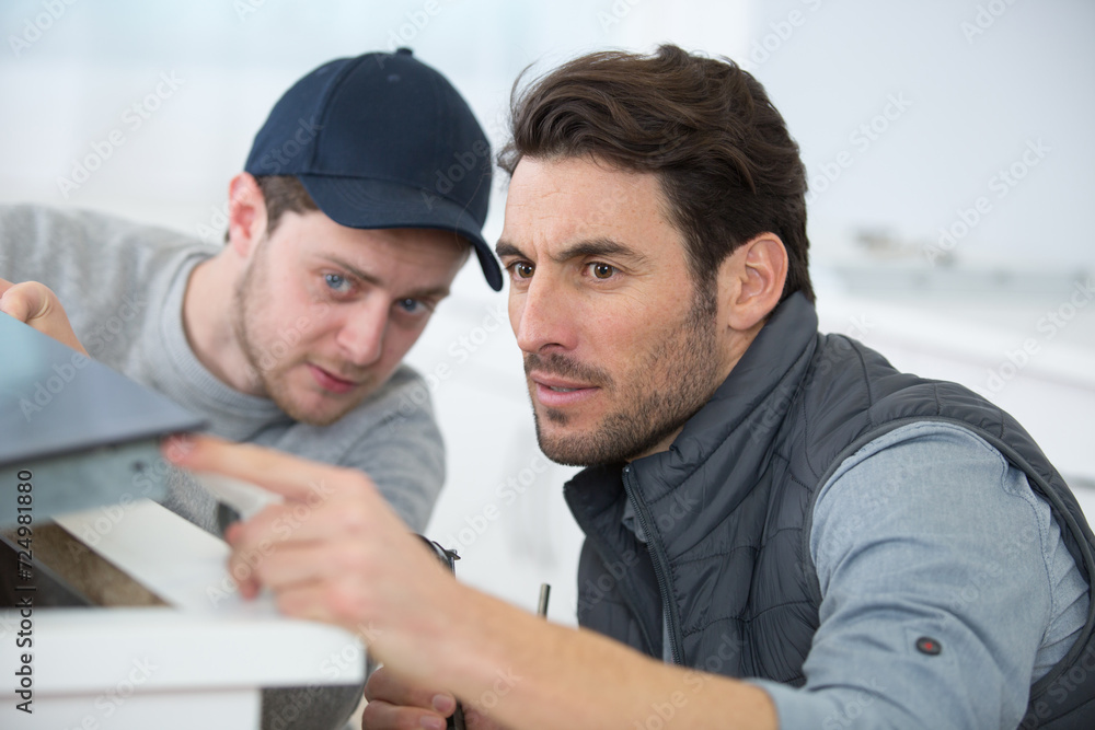 two men installing a new kitchen hob two men installing a new kitchen hob