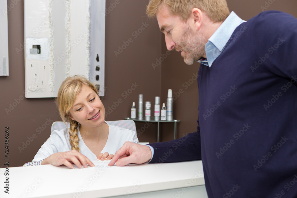 woman in a spa recpetion talks to customer woman in a spa recpetion talks to customer