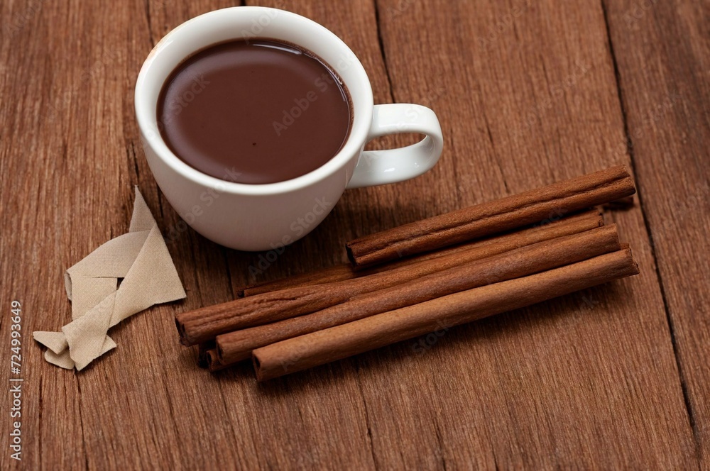 Cup of hot chocolate with cinnamon on wooden table, closeup Cup of hot chocolate with cinnamon on wooden table, closeup