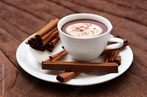 Cup of hot chocolate with cinnamon on wooden table  closeup