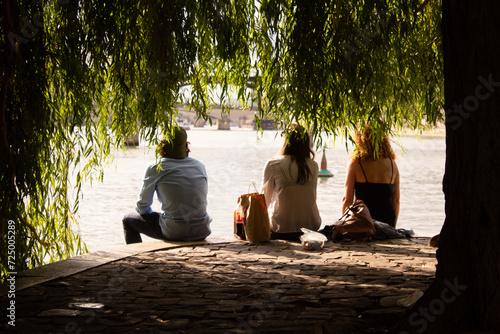 Picnic on Seine River,  three young persons having a meal in downtown Paris