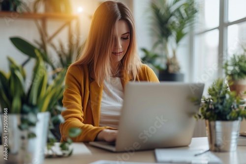 a woman is working on a laptop in an office