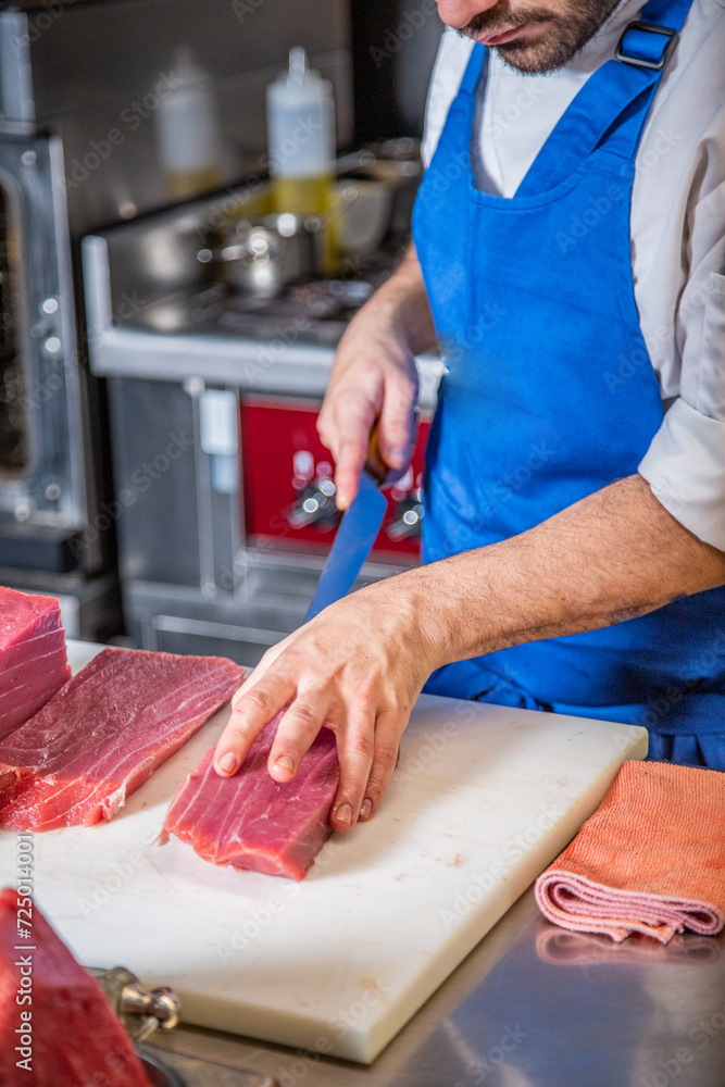 Chef corta atún rojo fresco salvaje en lomos para hacer tataki y sushi de atún rojo delicioso sobre una tabla de cortar en un restaurante