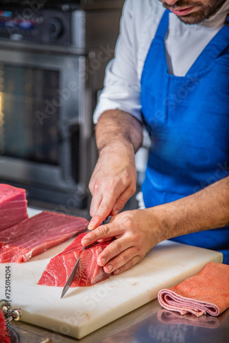 Chef corta atún rojo fresco salvaje en lomos para hacer tataki y sushi de atún rojo delicioso sobre una tabla de cortar en un restaurante