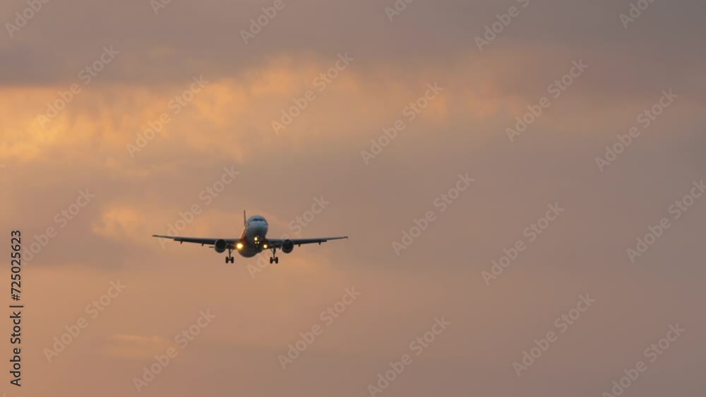 Cinematic shot of plane approaching before landing. Passenger airliner flies in the sunset sky, front view, long shot. Concept travel and tourism Cinematic shot of plane approaching before landing. Passenger airliner flies in the sunset sky, front view, long shot. Concept travel and tourism