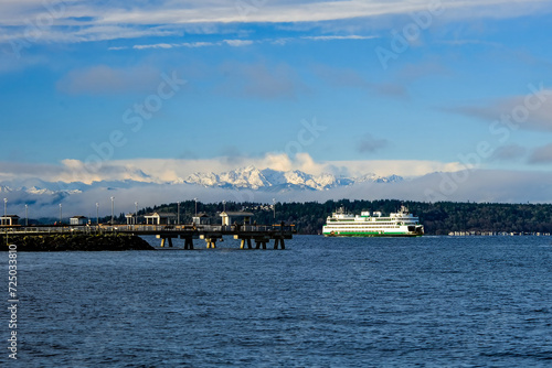 The Edmonds-Kingston Ferry in front of the Edmonds fishing dock, with the snowy Olympic Mountains in the distance, on a clear winter day