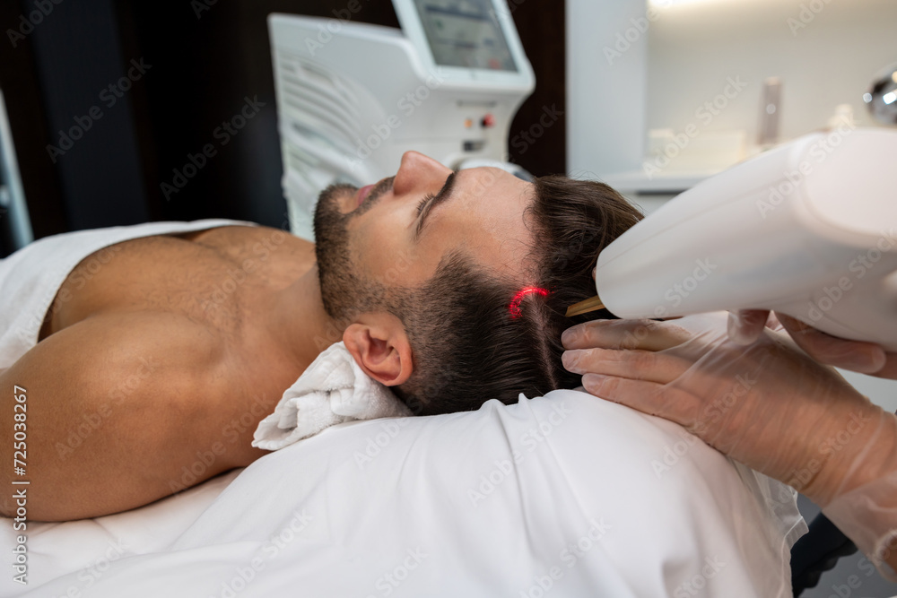 Customer in a beauty clinic having anti hair loss procedures Customer in a beauty clinic having anti hair loss procedures