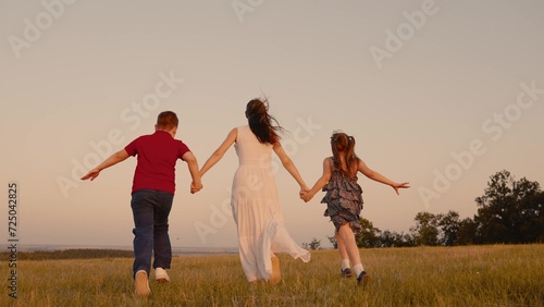 mother runs into sunset holding her child son daughter hand, happy family running, boy girl, spiritual connection with hand family, active family fun, building memories, childhood time dream big