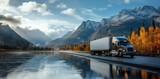 A solitary truck rests by the peaceful lake, surrounded by majestic mountains and reflected in the tranquil water, as the clouds drift by in the vast outdoor landscape