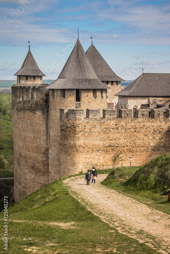 View of old castle Hotin near the river. Khotyn Fortress - medieval castle on yellow autumn hills. Ukraine, Eastern Europe. The architecture of the Middle Ages in our time.