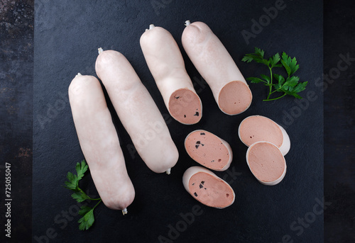 Traditionelle deutsche Kalbsleberwurst mit Bauernbrot angeboten als Nahaufnahme auf einer schwarzen Design Platte mit Textfreiraum