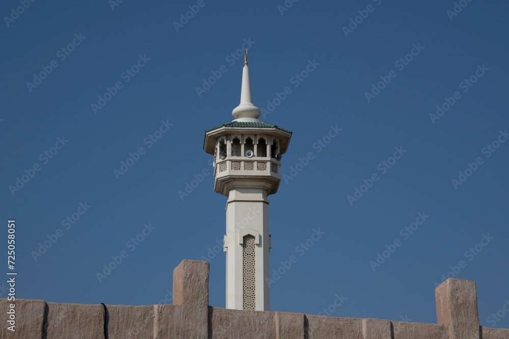 minaret behind a sandstone wall in the historic district of Dubai