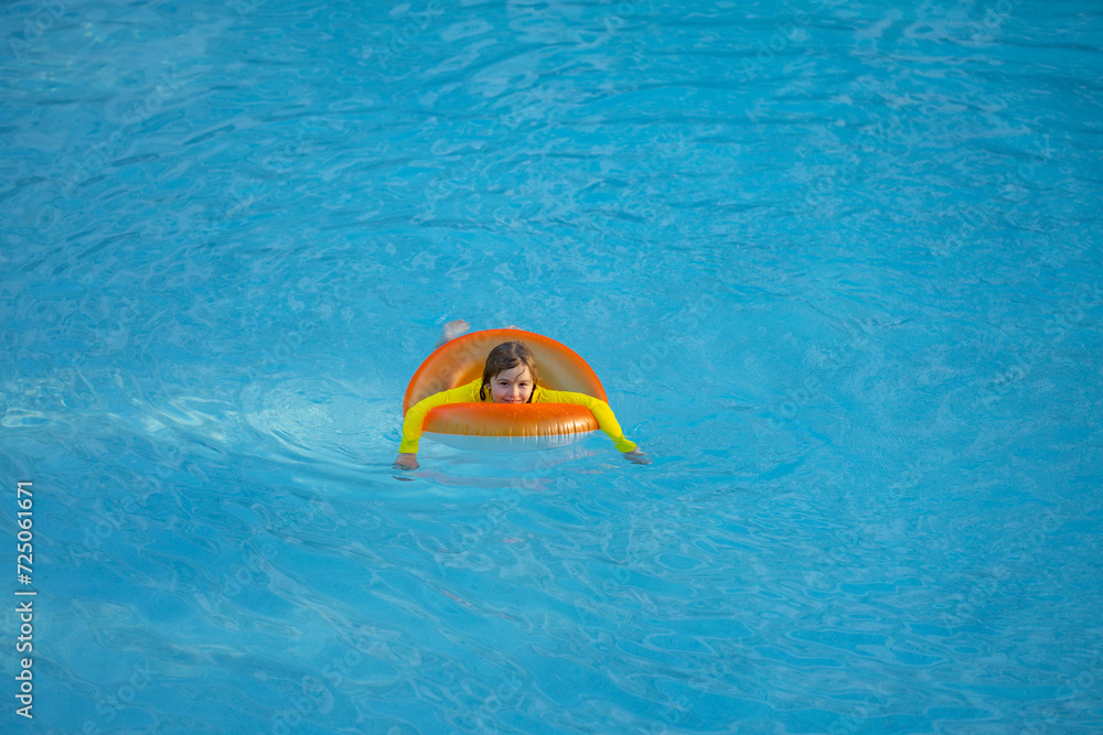 Summertime vacation. Kid with inflatable ring in swimming pool. Summer vacation. Summer holiday. Summertime kids weekend. Child in swiming pool. Kid floating in poolside. Summertime vacation. Kid with inflatable ring in swimming pool. Summer vacation. Summer holiday. Summertime kids weekend. Child in swiming pool. Kid floating in poolside.