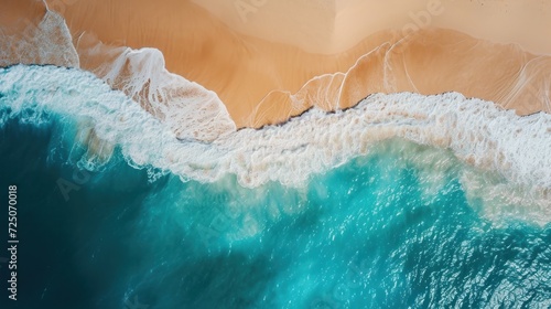 an aerial view of a beach with waves crashing on the sand and a blue body of water in the foreground.