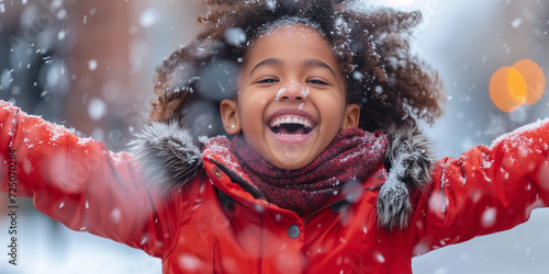 a really happy black little girl enjoy the snowfalling in winter and playing with the snowflakes photo