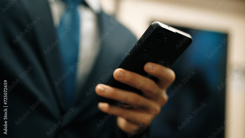 Closeup of business man hands looking phone while standing at train surrounded by people. Caucasian project manager checking email, planing marketing strategy with blurred background. Exultant.