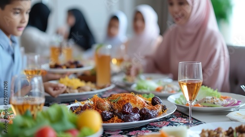 Happy Muslim family having iftar dinner to break fasting during Ramadan dining table at home group of people eating a healthy food dates