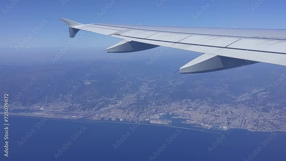 View from fly airplane to sky, wing above blue sea and shore of Genoa View from fly airplane to sky, wing above blue sea and shore of Genoa
