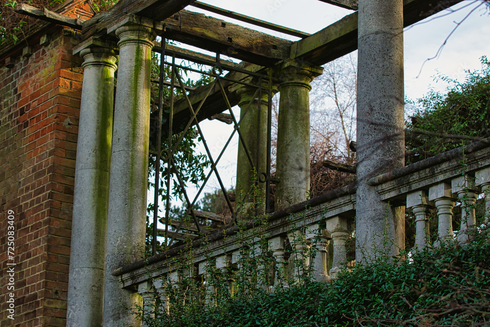 Old weathered columns and balustrade of an abandoned building with overgrown foliage. Old weathered columns and balustrade of an abandoned building with overgrown foliage.