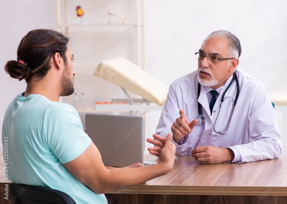 Fototapeta premium Injured young man visiting old doctor