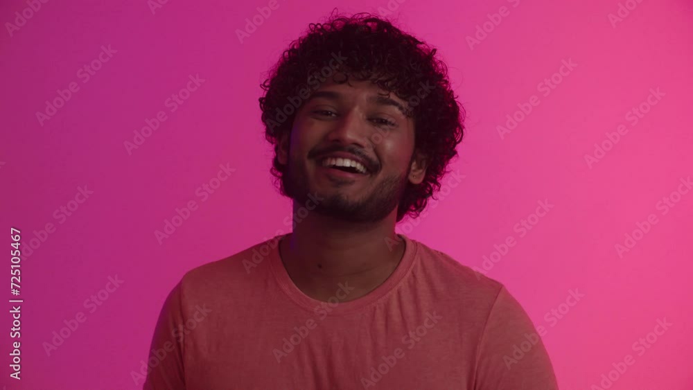 An attractive cheerful african american guy model or actor with a charming smile in positive emotions and happy mood laughs and poses for a television commercial against the backdrop of flickering An attractive cheerful african american guy model or actor with a charming smile in positive emotions and happy mood laughs and poses for a television commercial against the backdrop of flickering