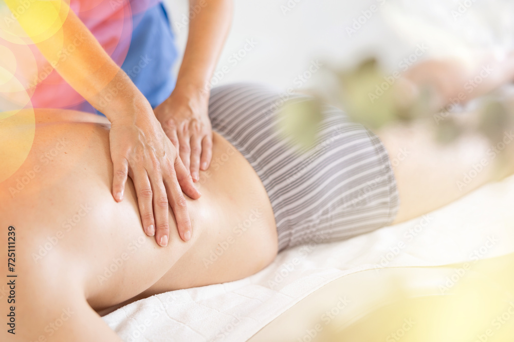 Naklejka premium Man gets back massage, close-up. Female masseur works out back and lower back area of male client