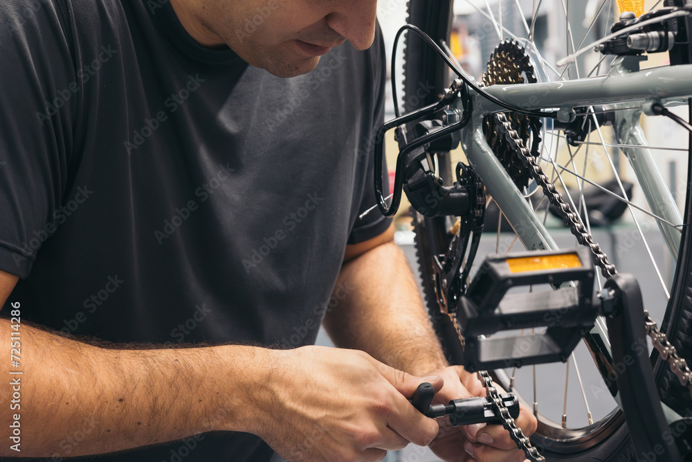Fototapeta premium anonymous mechanic cutting bike chain