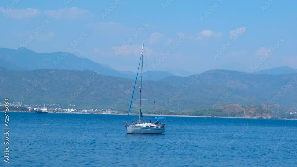 Fishing yacht glide by mountains. A small fishing yacht floating in the open air sea against coastline during summer weekend. Fishing yacht glide by mountains. A small fishing yacht floating in the open air sea against coastline during summer weekend.