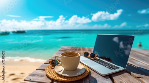 Fototapeta Naklejka Na Ścianę i Meble -  outdoor office or workspace with laptop and coffee cup at sea beach on summer holiday.
