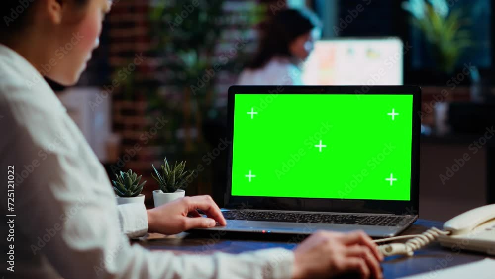 Worker looks over statistical financial data on chroma key laptop, researching data for company project. Businesswoman analyzing stock market figures and charts on mockup device