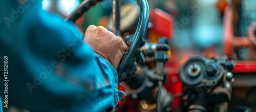 Control lever and mechanism for maneuvering a manual mini tractor, with a blurred background.