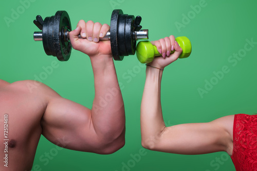 Dumbbell exercise. Male and female hands with dumbbells close-up. Training muscles. Female and male hand holds dumbbell. Muscular hands, exercises with dumbbells. Strong Dumbbell. Fitness and Sport.