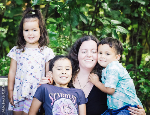 A close up image of a multiracial young family in New Zealand posing for their portrait.