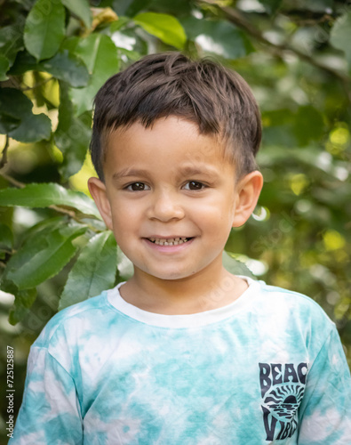 a young Maori boy poses for his portrait in an outdoor setting in New Zealand.