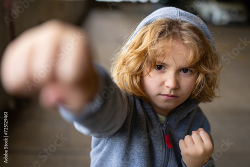 Aggressive bad child. Kid boy in hoodie fighting. Little kid boy fight outdoor. Angry boy fighting fist. Bad kids. Portrait of fighting kid. Bad Children fight. Aggression little boy. Bad behavioral.