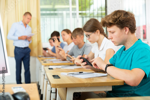 Classmates using their smartphones heavily during classes