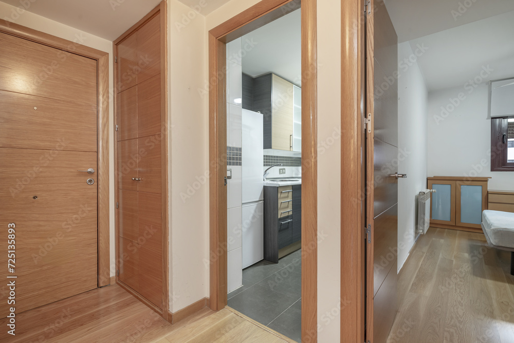 Hallway of a residential house with oak wood doors, access to kitchen and bedroom Hallway of a residential house with oak wood doors, access to kitchen and bedroom