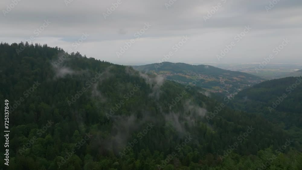 Drone flying forward over a mist-covered forest with clouds weaving through trees Drone flying forward over a mist-covered forest with clouds weaving through trees