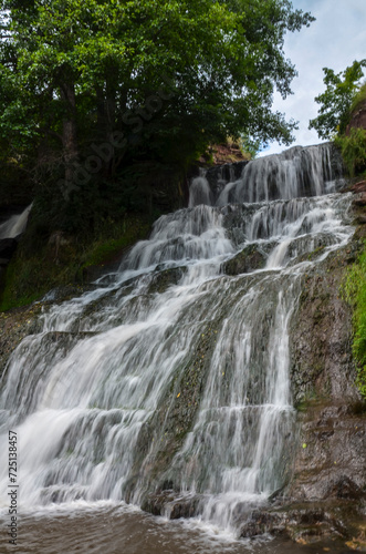 Fototapeta Naklejka Na Ścianę i Meble -  Scenic view of cascading 16 meters Dzhurinsky waterfall on the river Dzhurin. It is the largest in Ukraine plain waterfall. Nyrkiv, Ternopil region, Ukraine