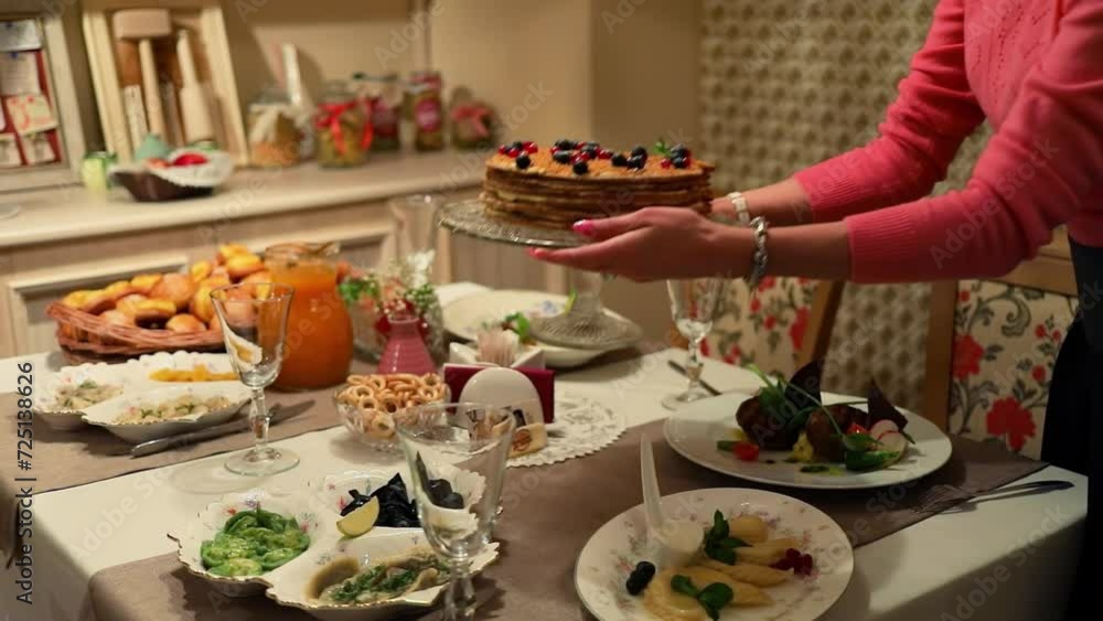 Woman puts cake on table among other meals, slow motion Woman puts cake on table among other meals, slow motion