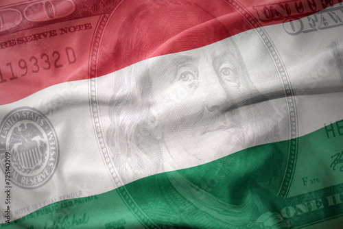 waving colorful flag of hungary on a american dollar money background. finance concept. photo