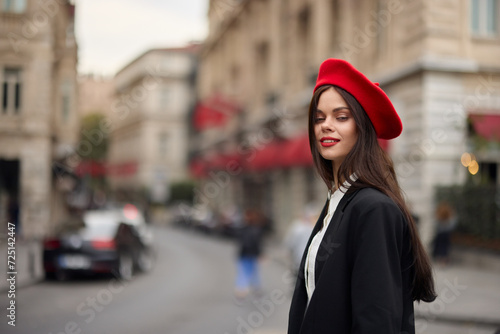 Fashion woman portrait smile with teeth standing on the street in the city background in stylish clothes red lips and red beret, travel, cinematic color, retro vintage style, urban fashion lifestyle.