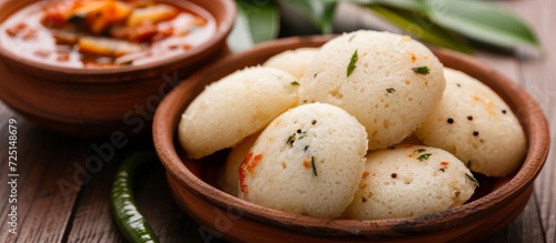 Idli vada, also known as medu wada, served with sambar or sambhar, is a type of rice cake. photo