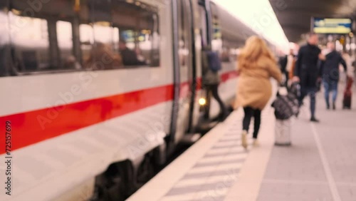 passengers late, running to German railway train, platform Frankfurt am Main station, out of focus video, people with luggage and backpack go to board, boarding travelers in cars, Frankfurt, Germany photo