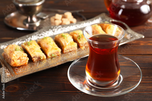 Traditional Turkish tea in glass and fresh baklava on wooden table