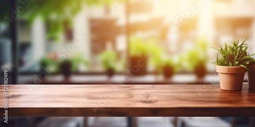 Wooden table with blurred kitchen window background for product or food display.