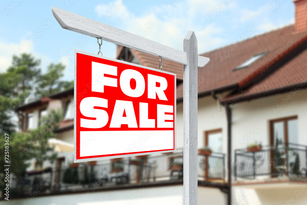 Sale sign near beautiful house outdoors. Red signboard with words Sale sign near beautiful house outdoors. Red signboard with words