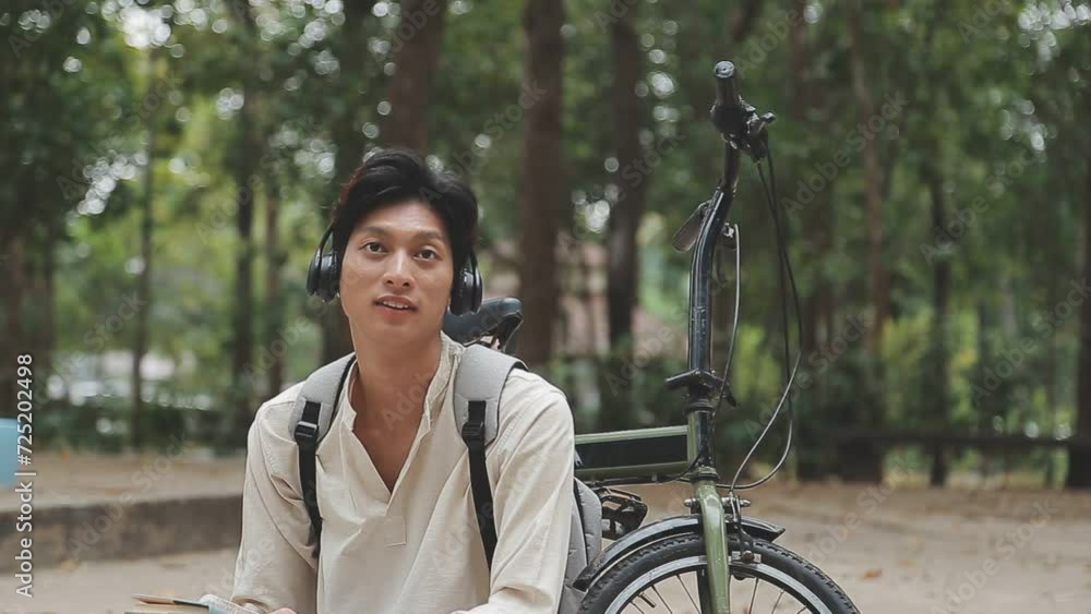 Man enjoying music using earphones while commuting to office on a bicycle. Businessman biking to office while listening to music. Man enjoying music using earphones while commuting to office on a bicycle. Businessman biking to office while listening to music.