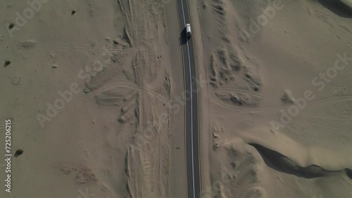 Drone view follows a truck through the middle of the desert. road in the middle of the desert