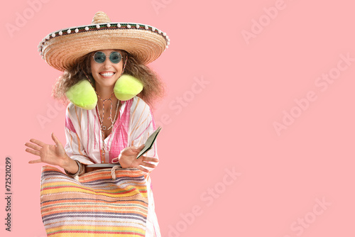 Mature woman in sombrero hat with passport and bag on pink background. Mexico s Day of the Dead  El Dia de Muertos  celebration